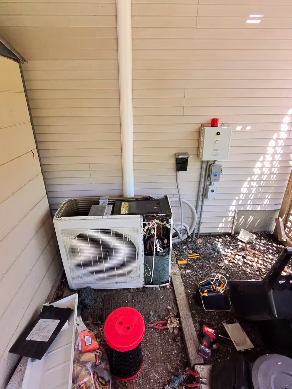 Residential outdoor air conditioning condenser installed beneath a deck
